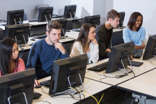 A group of young adult students using computers in a computer lab