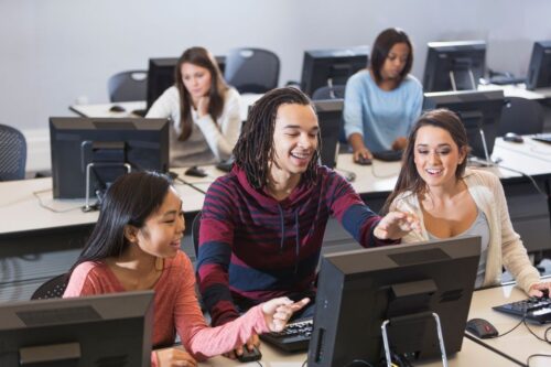 rows of students using computers in a computer lab